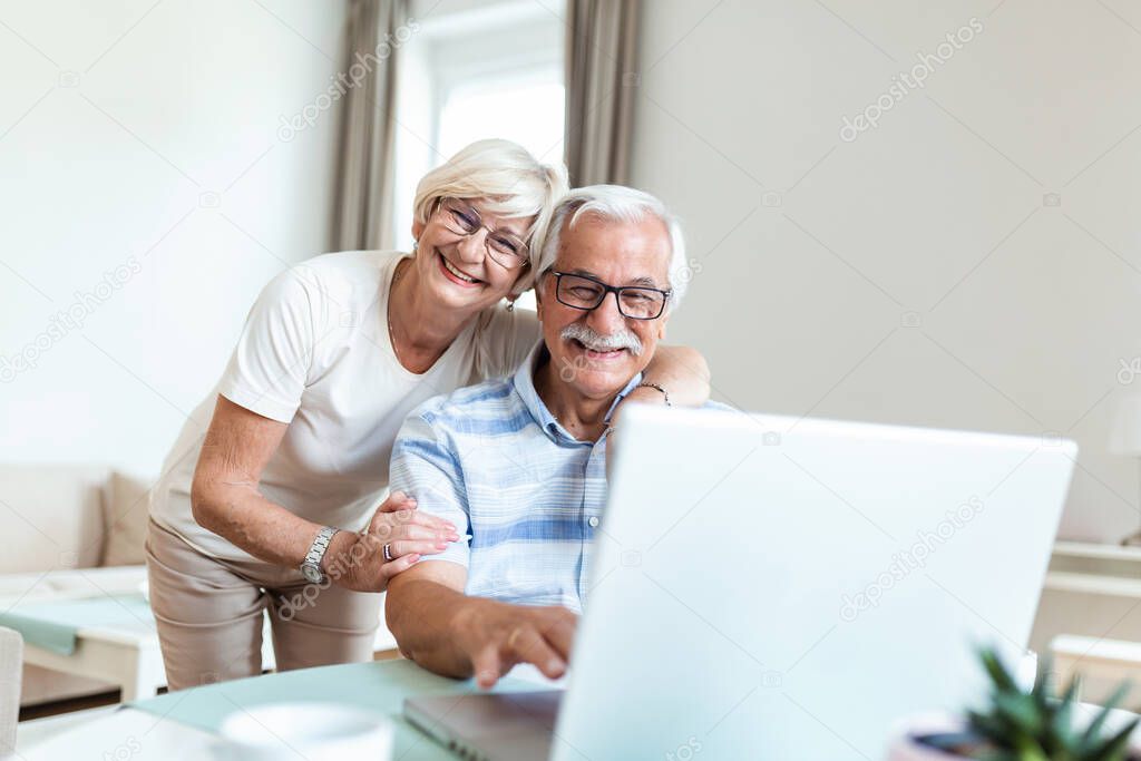 Elderly spouses at home. Wife hugs husband.Having pleasant conversation chatting with grown up children and grandchildren using wireless tech concept