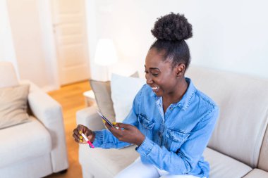 Mutlu, hamile kız hamilelik testini gösteriyor ve selfie çekiyor. Mutlu kadın cep telefonuyla hamilelik testinin fotoğrafını çekiyor ve sosyal medyada yayınlıyor..