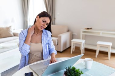 Bitkin hissediyorum. Hüsrana uğramış genç bir kadın yorgun görünüyor ve çalıştığı yerde boynuna masaj yapıyor.