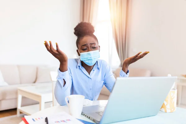 Businesswoman with protective mask working on laptop in the office. Female emloyee working protective facial mask working on laptop at workplace, keeping covid 19 dangerous virus quarantine measures.