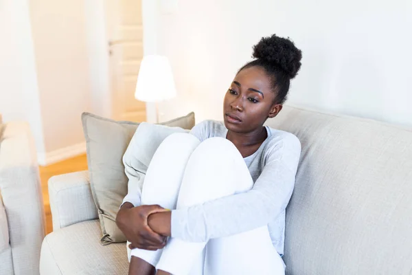 People, emotions, stress and health care concept - unhappy african american young woman touching her head and suffering from headache