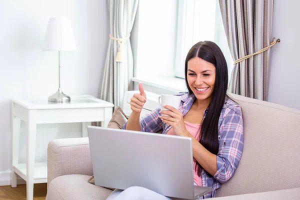 Success, victory or meeting deadline concept. Young,excited caucasian woman or teenager is holding her thumb up. Female working from home. Success concept.