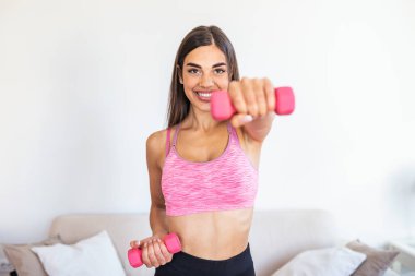 Athletic woman doing exercise for arms. Fitness model working out with dumbbells. Woman exercising with dumbbells. Fitness, workout, healthy living and diet concept. woman doing gymnastic exercises.