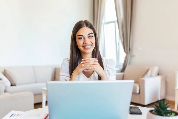 Happy young woman in headphones speaking looking at laptop making notes, girl student talking by video conference call, female teacher trainer tutoring by webcam, online training, e-coaching concept