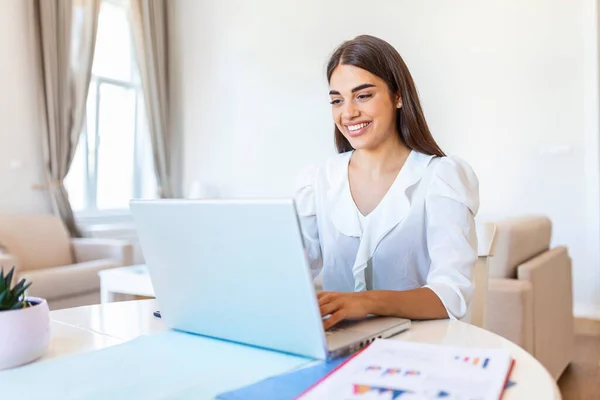 Happy young woman looking at laptop making notes, business woman talking by video conference call, Conference by webcam, online training, e-coaching concept