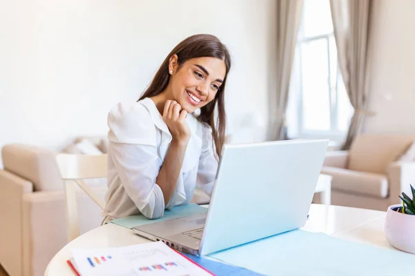 Happy young woman looking at laptop making notes, business woman talking by video conference call, Conference by webcam, online training, e-coaching concept