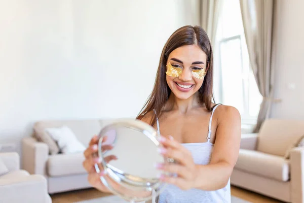 Portrait of pretty, nice woman with eye patches, having bags under eyes in the morning because of less sleep, showing an effect of perfect skin