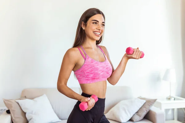 Strong fit woman working out with dumbbells. Attractive fit woman works out with dumbbells as a fitness conceptual. Active woman in sportswear working out.