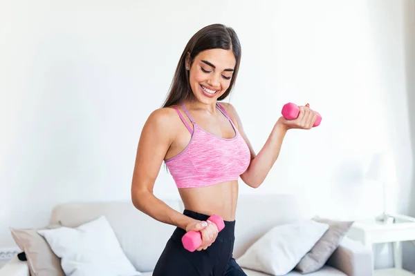 Strong fit woman working out with dumbbells. Attractive fit woman works out with dumbbells as a fitness conceptual. Active woman in sportswear working out.