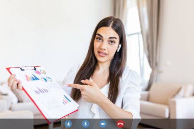 Focused businesswoman presenting charts and graphs on video call online. Young business woman having conference call with client. Closeup business woman working indoor.