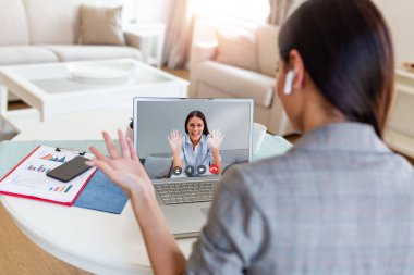 Businesswoman making video call to business partner using laptop. Close-up rear view of young woman having discussion with corporate client. Remote job interview, consultation, human resources concept