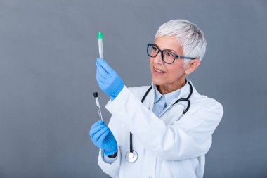 Female doctor or technician holding test tube Medical equipment. Blood test. Senior doctor woman working with blood samples in test tubes, closeup