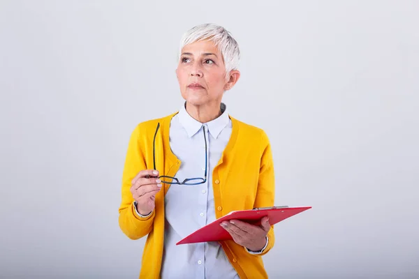 Portrait of mature business women With clipboard and document in hand with copy space isolated on white background. Thoughtful creative businesswoman looking away in office