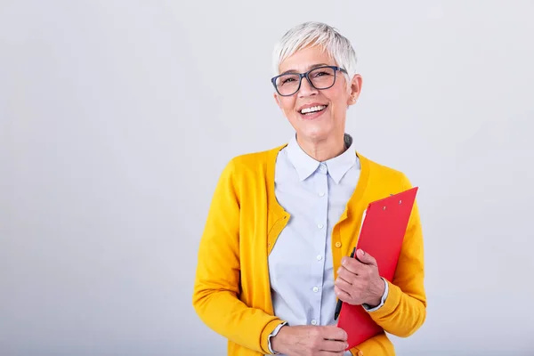 beautiful mature businesswoman writing in clipboard isolated on pink. Portrait smiling business women with clipboard and document in hands