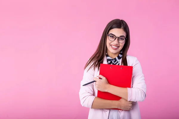 beautiful young businesswoman writing in clipboard isolated on pink. Portrait smiling young business women with clipboard and document in hands