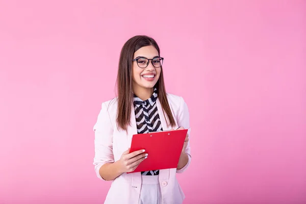 beautiful young businesswoman writing in clipboard isolated on pink. Portrait smiling young business women with clipboard and document in hands