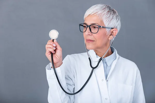 Female mature doctor with a stethoscope in the hands isolated on background. Doctor holds his stethoscope to insinuate that it\'s time for a check up in clinic banner