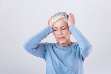 Attack of the monster migraine. Sinus pain. Unhappy Retired Senior Woman holding her head with pain expression . Face of senior woman suffering from headache