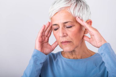 Canavar migreni nöbeti. Sinüs ağrısı. Mutsuz, emekli, yaşlı kadın acı ifadesiyle başını tutuyor. Baş ağrısı çeken yaşlı bir kadının yüzü.