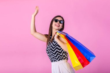 Cheerful happy woman enjoying shopping, she is carrying shopping bags and running to get the latest offers at the shopping center