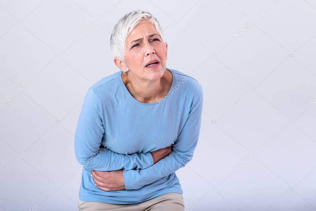 Unhealthy mature woman holding belly, feeling discomfort, health problem concept, unhappy older female holding her stomach, suffering from stomachache, food poisoning, gastritis, abdominal pain,climax