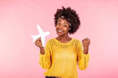 Afro-Amerikan pozitiflik fotoğrafı güzel güzel güzel bir kız uçak biletleri kazandı. Heyecanlı duygular içinde, uçak izole edilmiş, dalgalı pembe renkli arka plan.