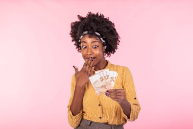 Elinde para tutan neşeli genç bir kadının portresi. Avro banknotları tutan Afrikalı Amerikalı kadın, mutlu ve memnun.