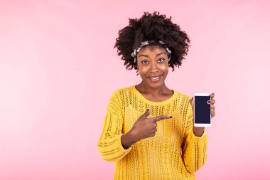 Genç bir kadın telefonda. Afro-Amerikalı kadın gülümsüyor ve akıllı telefonu işaret ediyor. Reklam kavramı