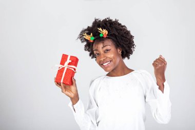 Güzel, güzel, çekici, siyah bir bayanın portresi. Hediye kutusu taşıyor, sürprizi merak ediyor. Beyaz arkaplan üzerinde izole edilmiş