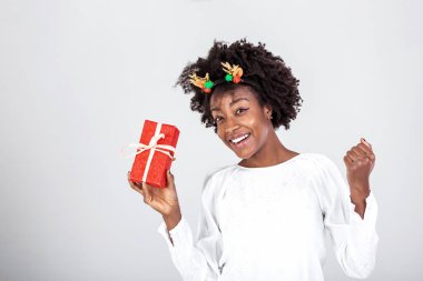 Güzel, güzel, çekici, siyah bir bayanın portresi. Hediye kutusu taşıyor, sürprizi merak ediyor. Beyaz arkaplan üzerinde izole edilmiş