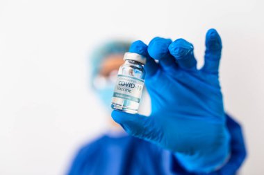 Coronavirus aşısı COVID-19 'un geliştirilmesi ve yaratılması. Coronavirus aşısı kavramı doktor mavi aşı kavanozunun elinde. Aşı Coronavirus 'a karşı savaş kavramı.