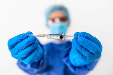 Kadın doktor COVID-19 aşısını elinde tutuyor. Sağlık ve Tıbbi Konsept. Aşı tüpü doz aşısı iğne şırıngası, tıbbi konsept aşı enjeksiyon tedavisi