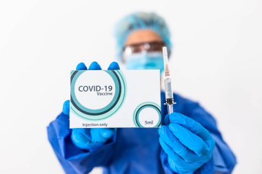 Doktorun elinde COVID 19 aşı ve şırınga var. COVID-19 'dan korunma, aşılama ve tedavi için kullanılıyor..
