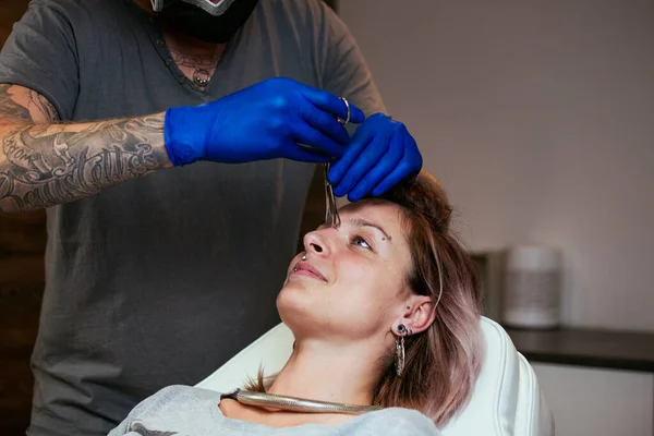 Young Woman Getting Pierced Her Eyes Man Showing Process Piercing — Stock Photo, Image