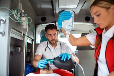 Acil yardım ekibi, yaralı hastaya sağlık hizmetleri hastanesine giderken tıbbi yardım sağlayın. Acil Bakım Asistanı Ambulans 'ta, Aralıksız Havalandırma Maskesi Kullanıyor. Yakın çekim..