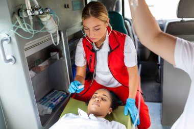 Stetoskoplu genç doktor hasta kalp ve akciğerleri dinliyor..