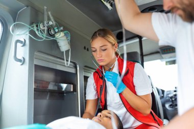 Stetoskoplu genç doktor hasta kalp ve akciğerleri dinliyor..