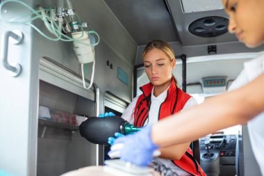 Sağlık görevlileri, hastaneye giderken yaralanan bir hastaya tıbbi yardım sağlıyorlar. Acil Bakım Asistanı, Silikon Elle Solunum Maskesi ile Havalandırma Maskesi Takıyor.