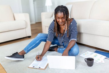 Olumlu genç kadın serbest yazar netbook 'ta video seyrediyor ve rahat bir evde kahve içiyor. Dizüstü bilgisayarda çalışan genç ve güzel bir iş kadını. İnternet 'e bağlanan serbest çalışan.