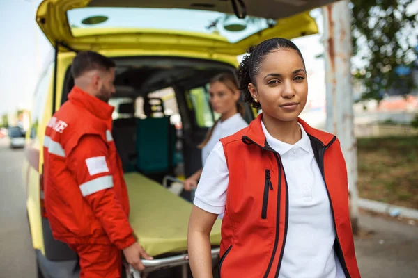 Joven Mujer Afroamericana Paramédica Sonriendo Pie Detrás Ambulancia Brazos Cruzados —  Fotos de Stock