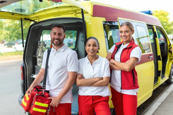 Tres Paramédicos Multirraciales Pie Frente Vehículo Ambulancia Llevando Equipo Portátil —  Fotos de Stock