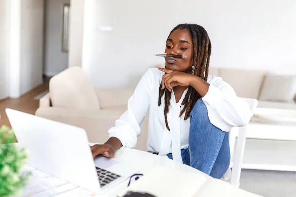 Female businessmen in casual wear work at the desk about accounting and business plan analysis. Young black woman at her desk in an office. Graphs and charts