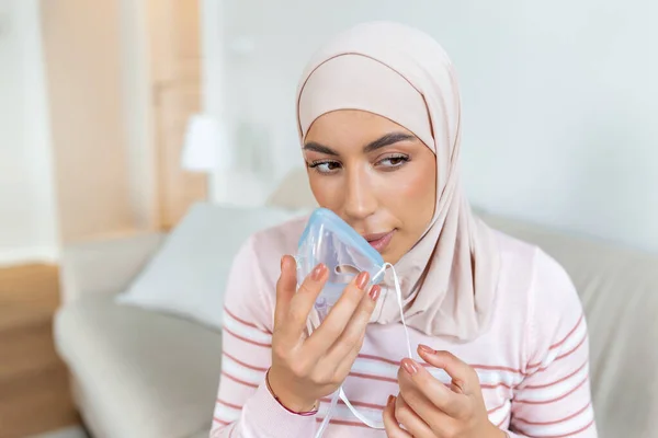 Sick muslim woman with hijab on oxygen mask inhalation, pneumonia coronavirus pandemic. ill woman wearing an oxygen mask and undergoing treatment. covid 19