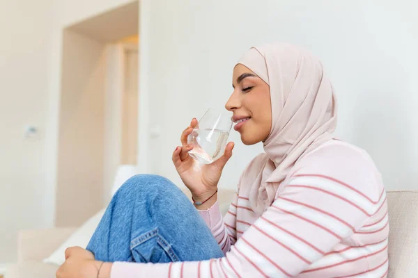 Piękna Młoda Muzułmanka Hidżabem Pijąca Świeżą Szklankę Wody Domu — Zdjęcie stockowe