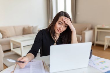 Dizüstü bilgisayarda çalışan Asyalı kadın, gülümsüyor. Modern apartmanda dizüstü bilgisayarla çalışan bir kadın. Evden dizüstü bilgisayarda çalışan moda kadın.