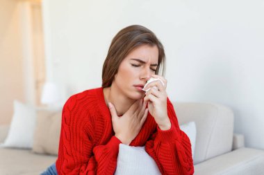 Hasta, çaresiz kadın grip olmuş. Rhinitis, soğuk, hastalık, alerji konsepti. Güzel hasta bir kadının burnu akıyor, burnu mendille sürtüyor. Hapşıran kadın. Esmer mendilin içinde hapşırıyor.