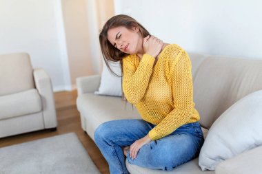 Evde sırt ağrısı çeken bir kadın. Bel Ağrısı. Kadın sırt ağrısı hisseder masaj yapar kaslar ağrır, üzgün kadın bel ağrısı çeker.