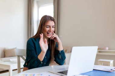 Shot of a businesswoman on a video call while sitting at her desk.Cropped shot of an attractive young woman using her laptop to make a video call at home