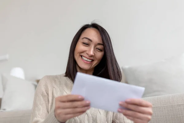 Cheerful Asian woman receiving invitation or good news about approved loan, mortgage, tax, insurance, getting notice about acceptance of statement