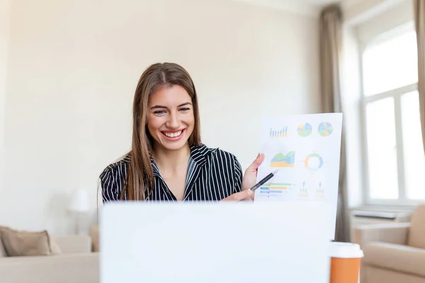 Focused business woman presenting charts and graphs on video call online. Young business woman having conference call with client on laptop. Young woman explaining how business work